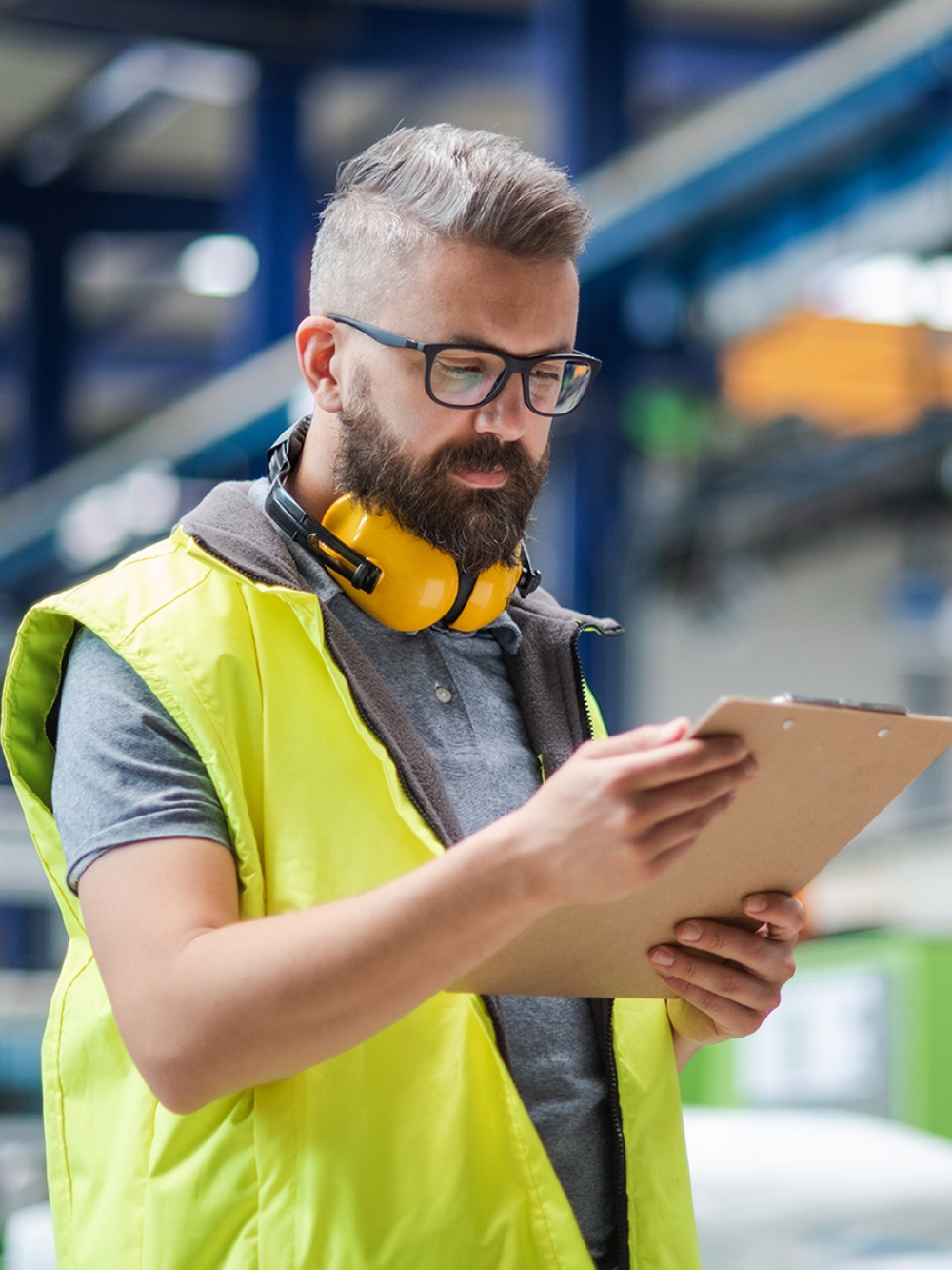 Un employé d'usine consulte des notes sur une tablette